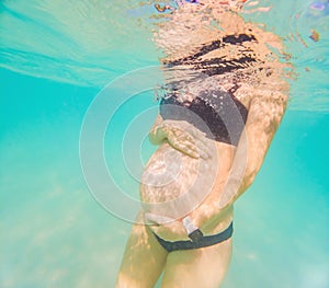 Pregnant woman underwater swimming in tropical sea. Healthy and active pregnancy. Young expecting mom on summer beach
