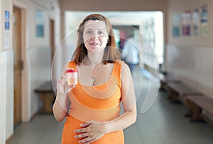 Pregnant woman with urinalysis sample photo