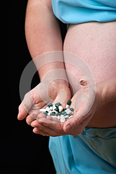 Pregnant woman uses vitamin tablets for healthy nutrition. pregnant woman uses vitamins. treatment of pregnant women. pregnancy