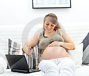 Pregnant woman using credit card to shop from net