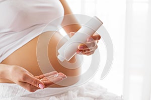 Pregnant woman using moisturizer