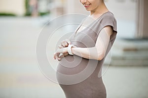 Pregnant woman using smart watch. Close-up