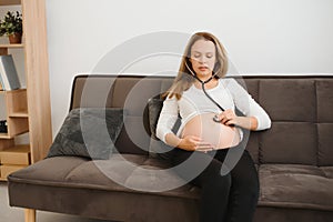 Pregnant woman using stethoscope examining her belly on sofa, Happy pregnant woman Concept