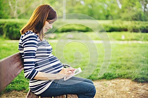 Pregnant woman using tablet