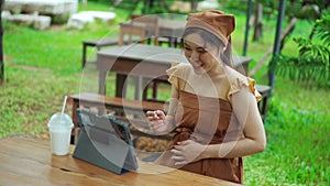 Pregnant woman using tablet in garden