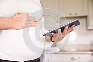 Pregnant woman using tablet pc