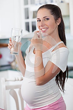 Pregnant woman with vitamin's pill.