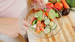 Pregnant woman waiting for baby cooking and eating fresh vegetable salad on kitchen. Concept of healthy lifestyle and