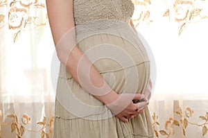 Pregnant woman hugs her tummy