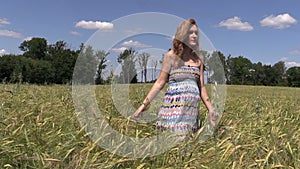 Pregnant woman walk between ripe barley plant crop ears