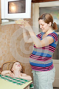 Pregnant woman warms up food photo