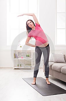 Pregnant woman warmup stretching training indoors