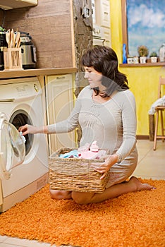 Pregnant woman washes baby clothes