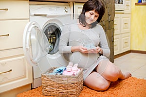 Pregnant woman washes baby clothes