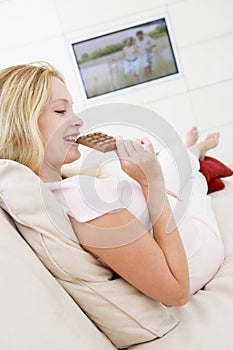 Pregnant woman watching television and eating