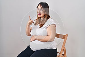 Pregnant woman wearing band aid for vaccine injection smiling happy and positive, thumb up doing excellent and approval sign