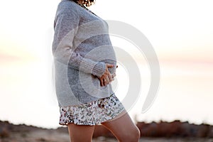 Pregnant woman wearing sweater while walking outdoor