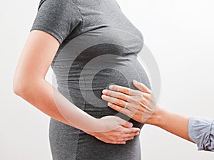 Pregnant woman wife and husband touch belly with love