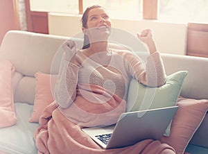 Pregnant woman working on a couch.