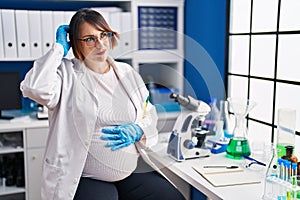 Pregnant woman working at scientist laboratory confuse and wondering about question