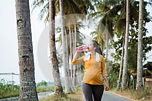Pregnant woman after workout drinking a bottle of water