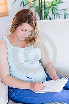 Pregnant woman writing down some notes