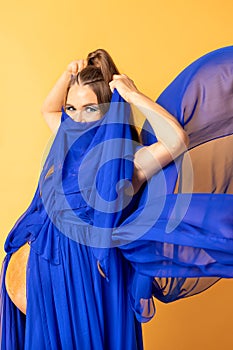 Pregnant woman on yellow background with big tummy, waiting for baby.