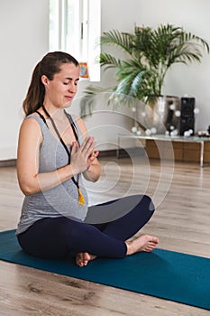 Pregnant woman in yoga studio meditating on mat