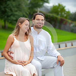 Pregnant woman and young father outdoor