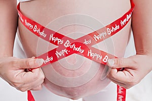 pregnant women 9 month Close up measuring belly in a white background.