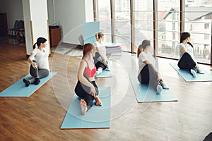 Pregnant women doing yoga with a coach