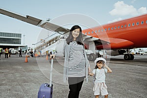 Pregnant women and his daughter like to stand beside the plane