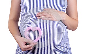 Pregnant women holding pink heart symbol placed on belly isolated on white background