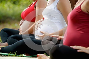 Pregnant Women In Prenatal Class Touching Belly photo