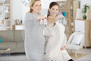 pregnant women showing baby shoes