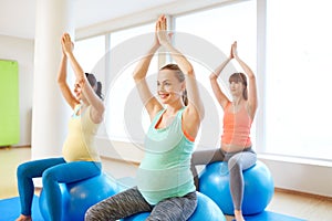 Pregnant women sitting on exercise balls in gym