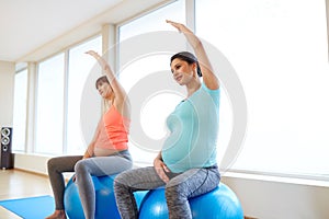 Pregnant women training with exercise balls in gym