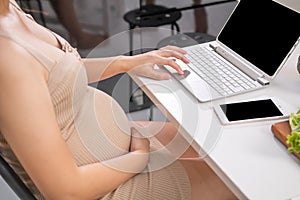 Pregnant women use internet by laptop for seeking