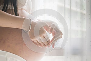 Pregnant women in wear white underwear touching her belly with her hands. expectation baby.