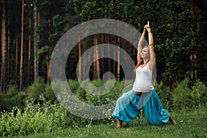 Pregnant yoga prenatal maternity doing different exercises. in the park on the grass, breathing, stretching, statics.