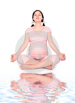 Pregnant yoga woman on beach