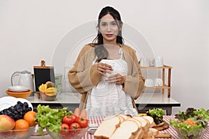 Pregnant Young Asian Woman Cooking vegetables. Healthy Food and drink - Vegetable Salad. Dieting. Dieting Concept. Healthy
