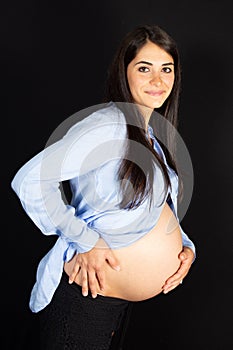 Pregnant young pretty woman on black background