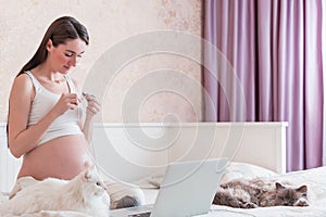 The pregnant young woman in a bedroom