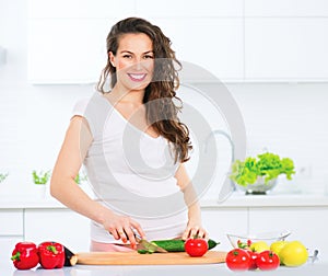 Pregnant young woman cooking vegetables