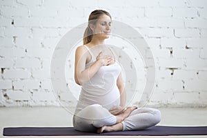 Pregnant young woman doing prenatal yoga. Pranayama photo