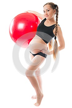 Pregnant young woman doing yoga on fitball