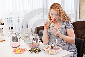 Pregnant young woman eating sweets