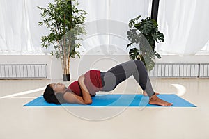 Pregnant young woman exercising on yoga mat