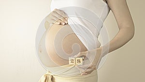 Pregnant woman belly with the week number 28